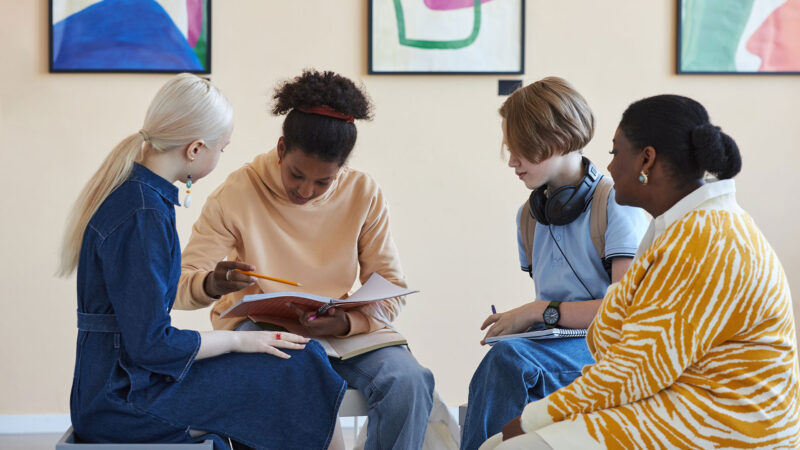 Teenagers Sitting In Circle And Holding Books